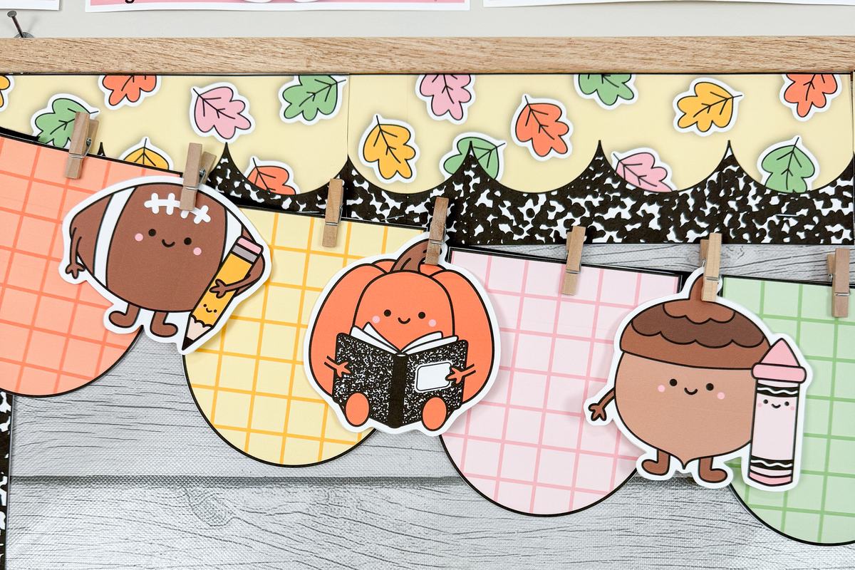 Close-up of a fall classroom pennant banner with gingham pennants, a football, a pumpkin reading a composition notebook and an acorn holding a crayon
