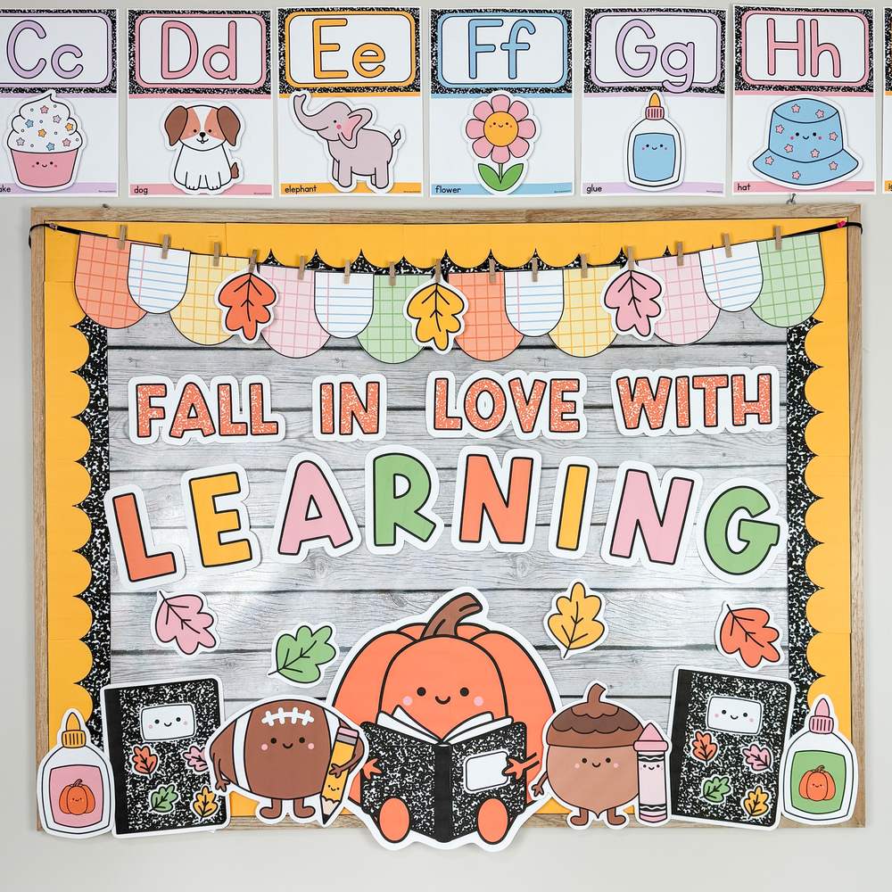Fall classroom decor bulletin board that says FALL IN LOVE WITH LEARNING with a pumpkin reading a composition notebook, football, acorn and leaf cutouts